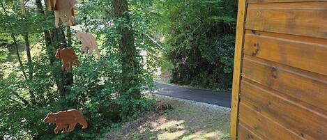 A wooden cabin with a dirt path leading through a wooded area.
