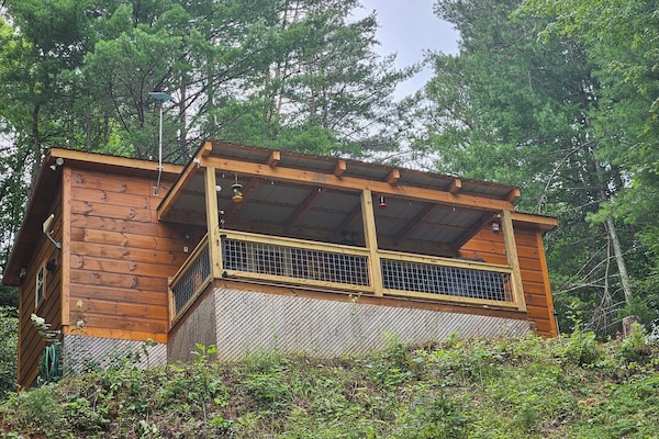 Cabin on the hill in summer, with new covered deck added in 2024.