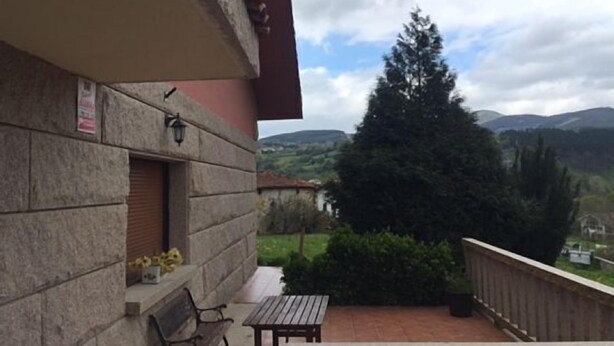 A balcony with a stone wall, a wooden table, and a bench. - Rural house (full rental) Chalet in Arcentales for 12 people (Arcentales)