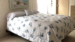 A bedroom with a bed, a painting on the wall, a window with curtains, and a door. - Single family home - Less than 4 miles from Rehoboth Beach Boardwalk (Rehoboth Beach)