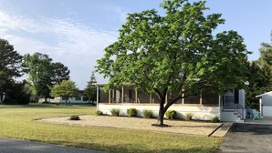 A residential property with a covered patio, a lawn, and a driveway. - Single family home - Less than 4 miles from Rehoboth Beach Boardwalk (Rehoboth Beach)