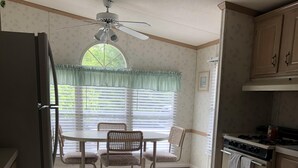 A kitchen with a dining table and chairs, a ceiling fan, and a window with blinds. - Single family home - Less than 4 miles from Rehoboth Beach Boardwalk (Rehoboth Beach)