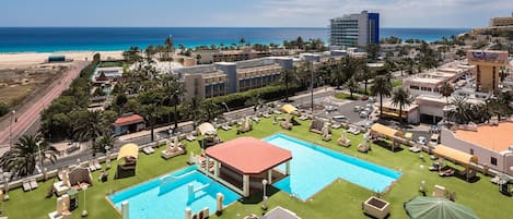 Un hôtel doté d’un grand espace piscine, de plusieurs piscines et offrant une vue sur la plage.