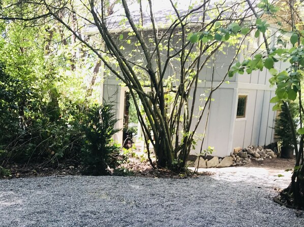 A gravel driveway leading to a house with a white exterior and a small window.