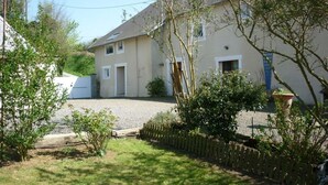 Une maison à deux étages avec une allée en gravier et une clôture en bois.