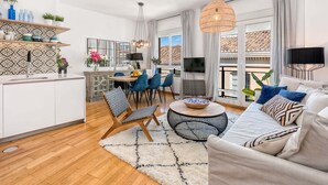 Ein modernes Wohnzimmer mit Sofa, Couchtisch und Essbereich.