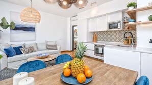 Eine moderne Küche mit weißen Schränken, einer Mikrowelle und einer gemusterten Spritzschutzwand.
