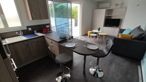 Una cocina moderna con comedor, sofá y televisor.