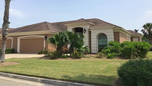 A single-story house with a brown roof, a garage, and a well-maintained lawn. - The Seahorse- 7 Hac (Laguna Vista)