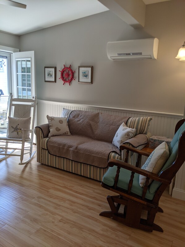 A living room with a striped sofa, a rocking chair, and a wooden coffee table. - Location, location, location (Old Orchard Beach)