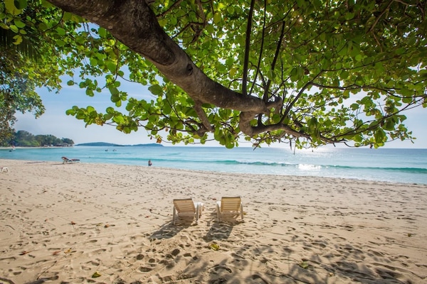 On the beach, white sand, sun loungers, beach towels