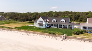 A two-story house with a large front porch, a swimming pool, and a beach view. - Luxury Oceanfront 5 Bedroom 3.5 Bathroom Private Parsons Beachfront Paradise (Kennebunk)