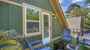 A green building with a white door and windows, outdoor seating with blue chairs, and a small table. - The Fairy Tern, PRIVATE/ONE-OF-A-KIND 4bd/3bth on Tybee's North End (Tybee Island)
