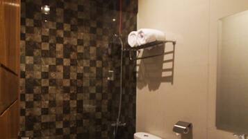 Un baño moderno con pared de baldosas a cuadros, un inodoro con toalla, un lavabo y una ducha.