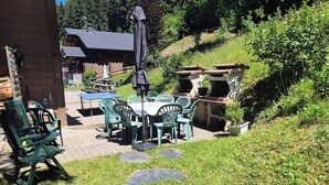 A patio area with outdoor furniture, a barbecue grill, and a stone pathway. -  Exceptional Chalet –11 guests – 230 m² (74390 - CHATEL)