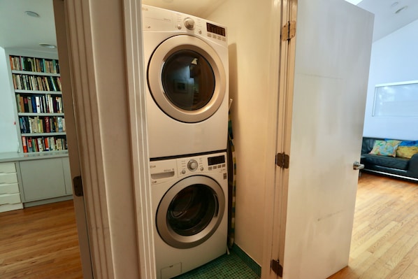 Laundry room. Stacked washer and dryer. LR on right, bedroom 1 on left.