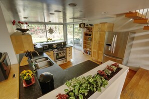 Kitchen. View over built-in planter. Dining room in background.