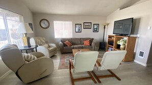 A living room with a sofa, armchairs, a coffee table, a TV, and a fireplace. - 3 bedrooms, 2 bathrooms (Sisters)