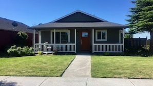 A single-story house with a front porch, a red door, and a small front yard. - 3 bedrooms, 2 bathrooms (Sisters)