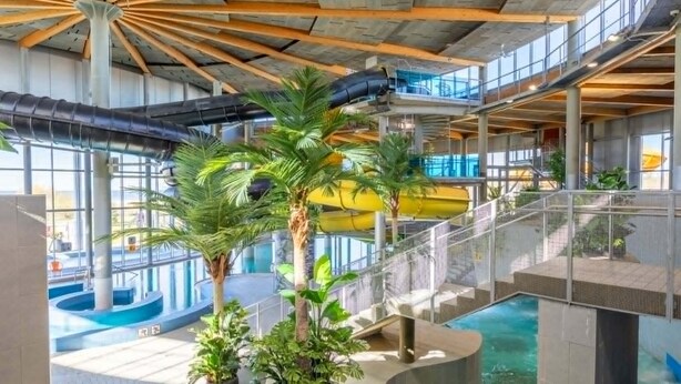 Een binnentuin met een centrale trap, meerdere verdiepingen en een zwembad.