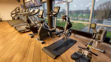A gym with treadmills, elliptical machines, and a rowing machine.