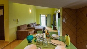 A dining area with a table set for four, a sofa, and a television in the background. - Apartment in Vinišće with Balcony, Air condition, WIFI, Washing machine (4753-3) (Vinišce)
