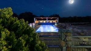 A swimming pool with a stone deck, a covered seating area, and a view of the night sky with stars and a full moon. - Apartment in Vinišće with Balcony, Air condition, WIFI, Washing machine (4753-3) (Vinišce)