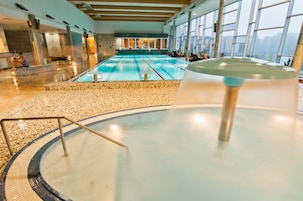 Una piscina techada, sillones reclinables de piscina