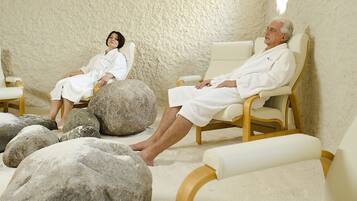 A spa room with two reclining chairs and large rocks on the floor.