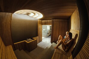 A sauna room with wooden walls and a bench.