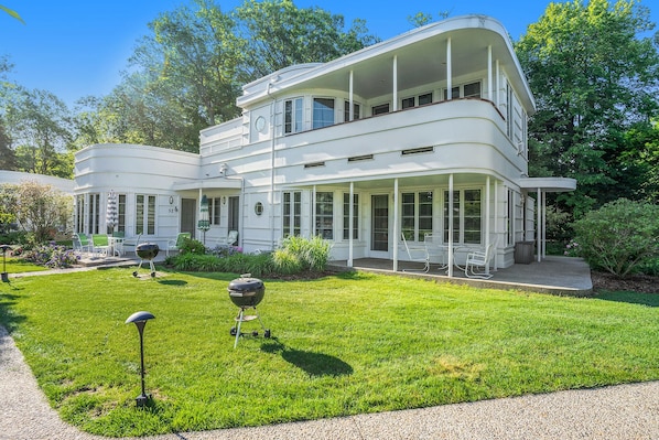 Une maison à deux étages avec un porche abrité et une pelouse bien entretenue.