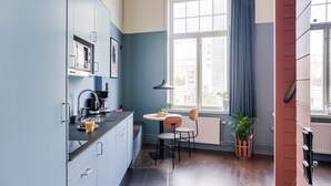 A modern kitchen with a dining area, large windows, and a potted plant. - The Nooq Malmö (Malmö)