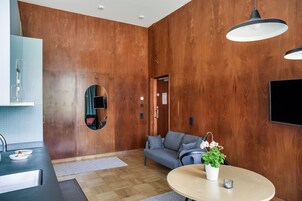 Una cocina moderna con un lavabo, un espejo redondo y un sofá gris.