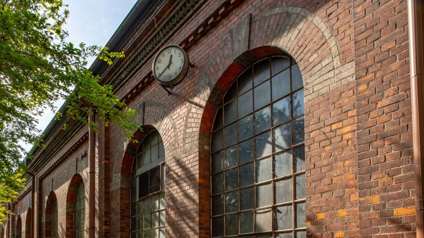 A brick building with large arched windows and a clock on the wall. - The Nooq Malmö (Malmö)