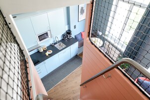Una cocina compacta con microondas, cafetera y lavabo.