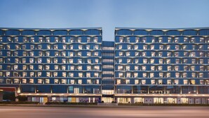 A modern hotel with a symmetrical facade, multiple balconies, and a well-lit entrance. - Flyzoo Hotel - Alibaba (Hangzhou)