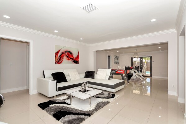 A modern living room with a white sectional sofa, a coffee table, and a rug. - Tropical paradise wonderful, weekly and monthly discounts available!. (Cutler Bay)