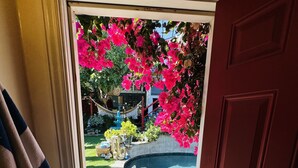 Puerta que da a un patio trasero con piscina, jardín y un bote.