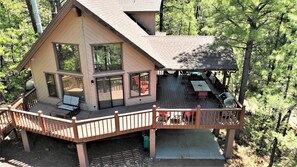 A two-story cabin with a deck, large windows, and outdoor seating. - Beautiful Naughty Pines Lodge! 2 Masters, Loft & large deck in Munds Park!  (Munds Park)