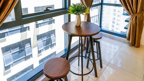 A modern room with a large window, two round wooden tables, and matching stools. - 3 Tower by Plush (Kuala Lumpur)