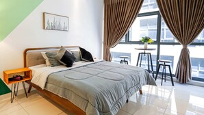 A modern bedroom with a bed, a nightstand, a window with curtains, and a view of the outside. - 3 Tower by Plush (Kuala Lumpur)