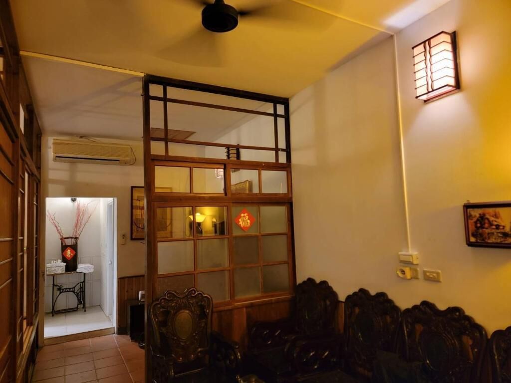 A traditional room with a wooden partition, a ceiling fan, and a wall-mounted light fixture.