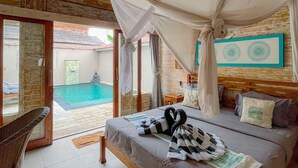 A bedroom with a bed, a chair, a pool view, and a wooden ceiling. - Gilizen Resort - Private Pool Villas (Gili Air)