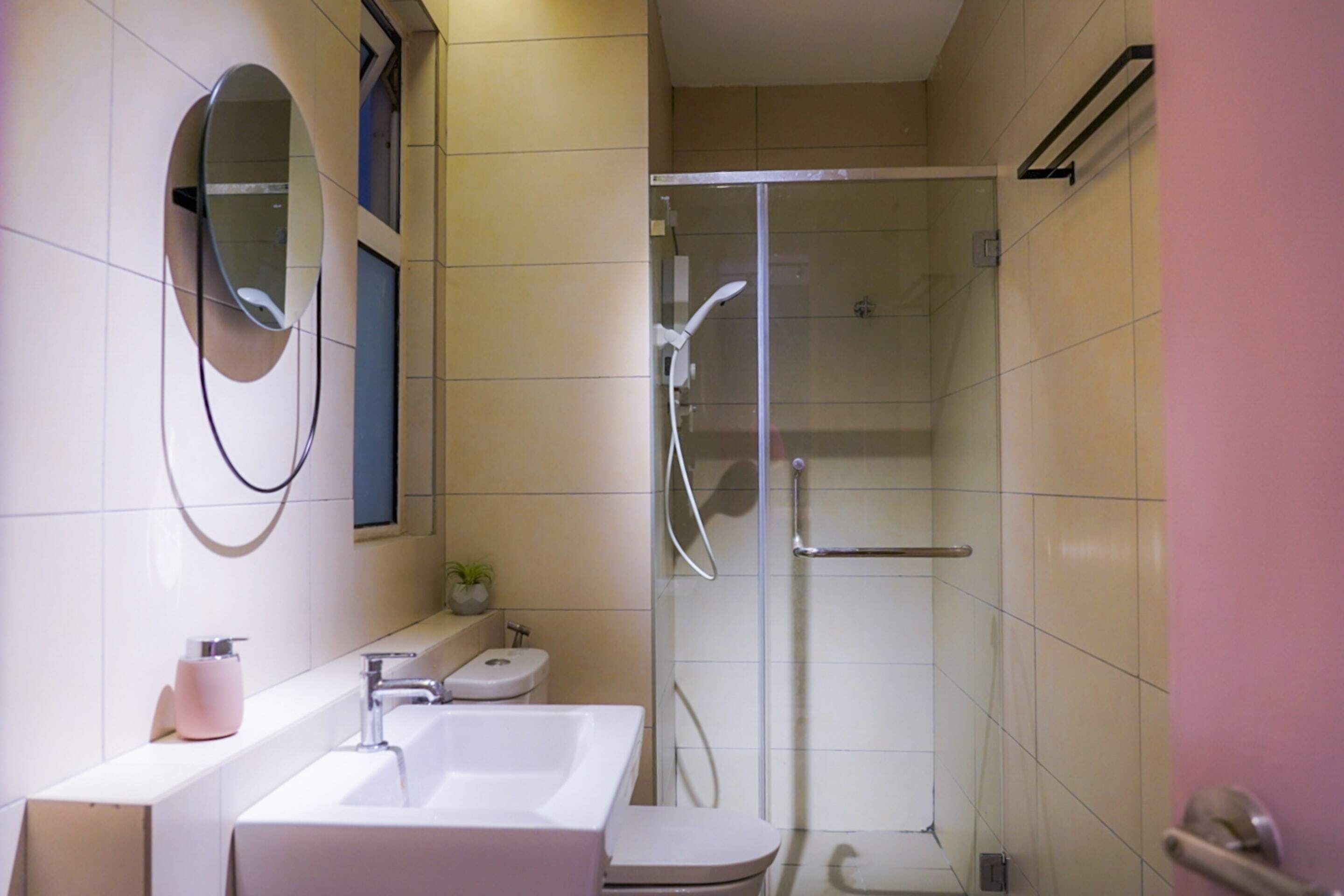 A bathroom with a sink, toilet, and a glass-enclosed shower area.