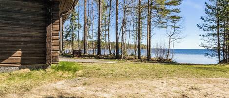Una cabaña con vistas a un lago y un bosque.
