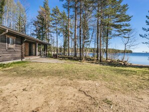 A cabin with a porch, a grassy yard, and a lake view. - Kesäranta 7 by Interhome (Kesälahti)