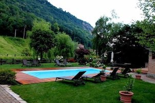 Una piscina al aire libre de temporada, sillones reclinables de piscina