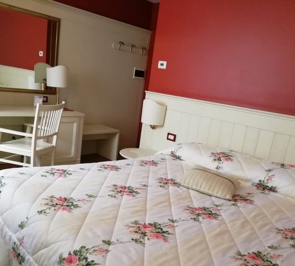 Una habitación de hotel con una cama, un escritorio y una silla.