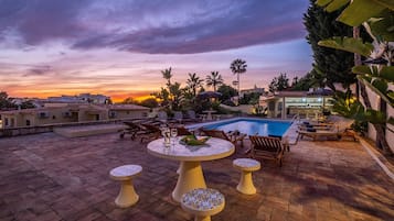 A heated pool, sun loungers