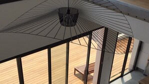 A modern living room with a large window, a sofa, and a coffee table. - Villa of archi 180m2 new (Saint-Aunès)